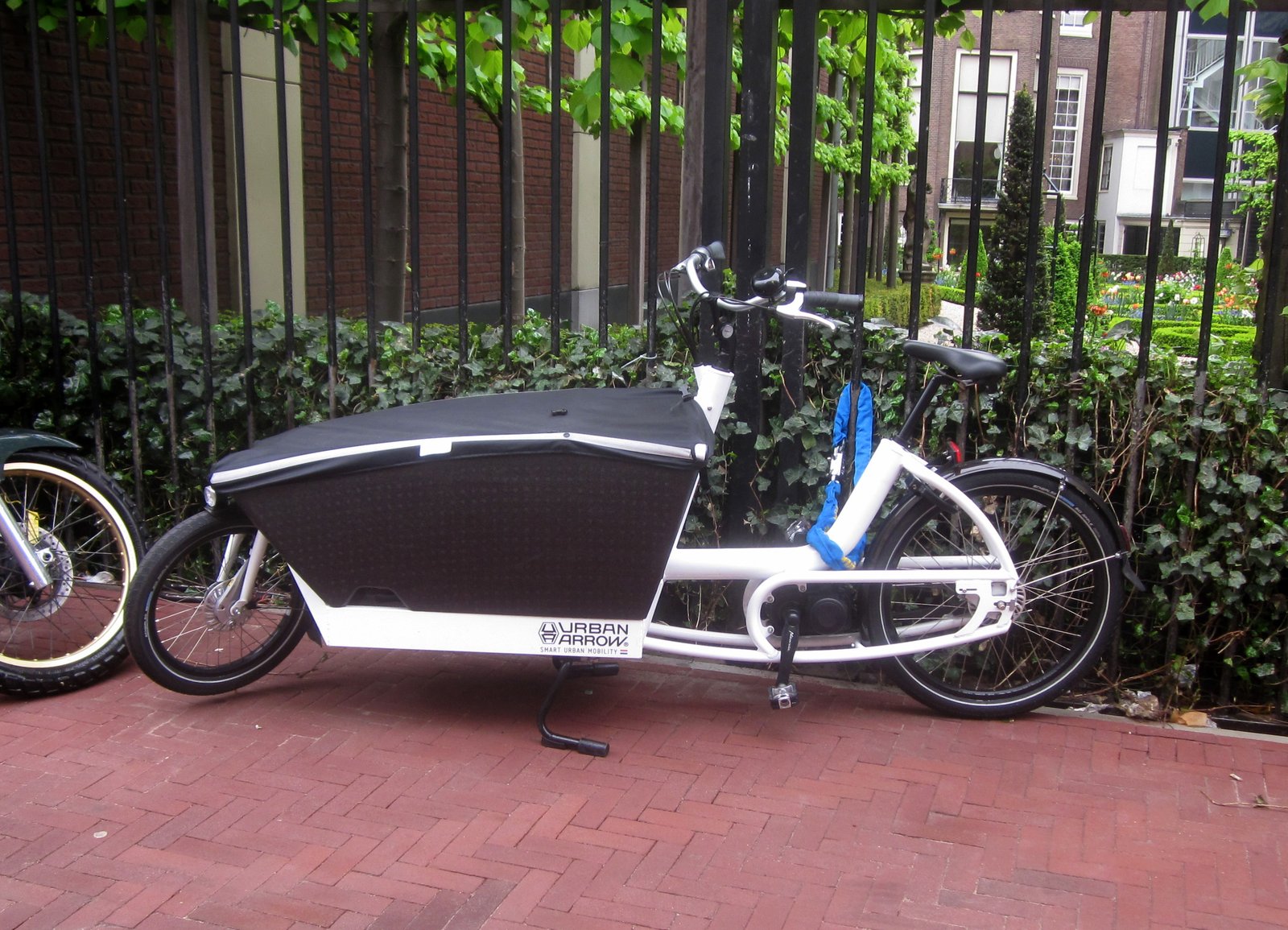 Urban Arrow Family electric long-john cargo bike (bakfiets), white frame with black cargo box, parked in Amsterdam, photograph