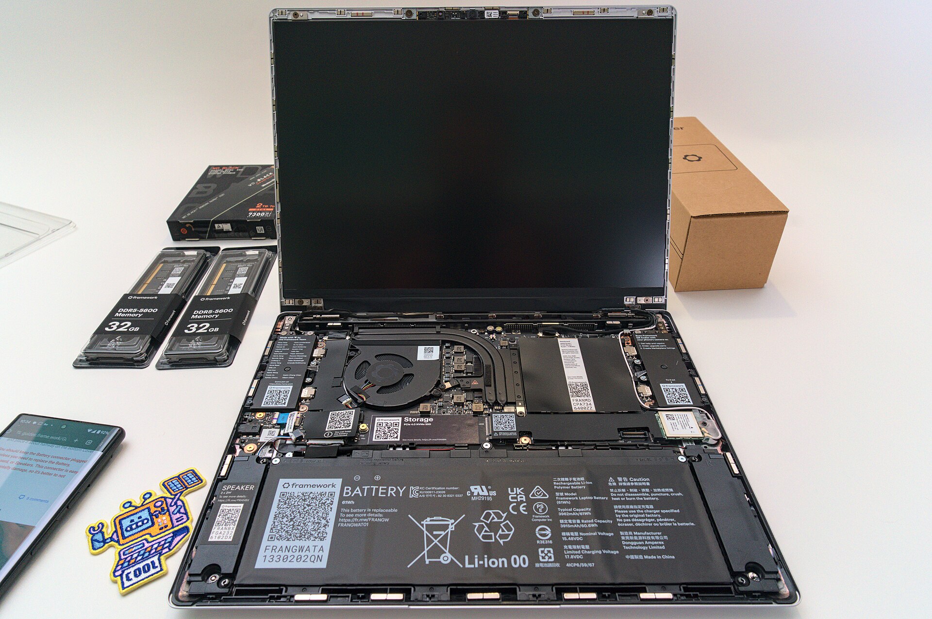 Framework Laptop 13 DIY setup with modular internals, QR-coded battery, memory and storage modules, product photograph